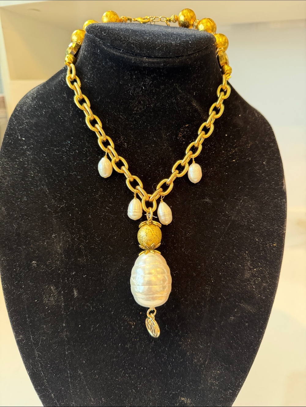 Susan Shaw
Gold chain w freshwater pearl accents. Glass pearl is the pendant.